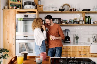 Çift gülüyor ve mutfakta duruyor..
