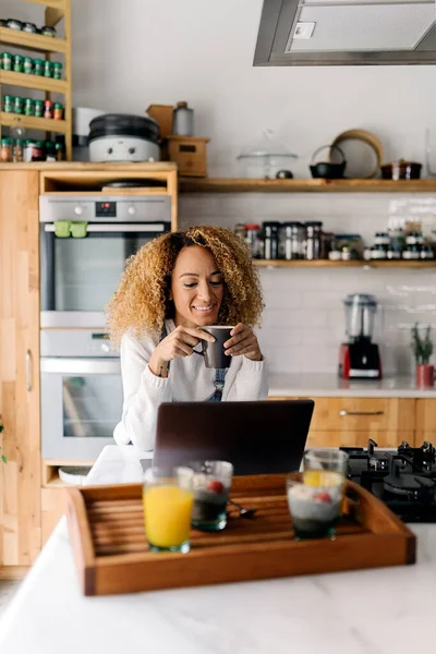 Женщина с ноутбуком на кухне. — стоковое фото