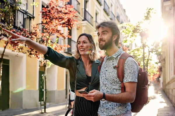 Couple on street pointing at something. — Stockfoto