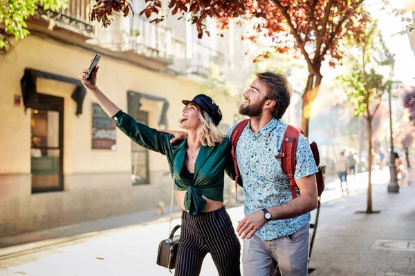 Para spacerująca ulicą robiąca selfie — Zdjęcie stockowe