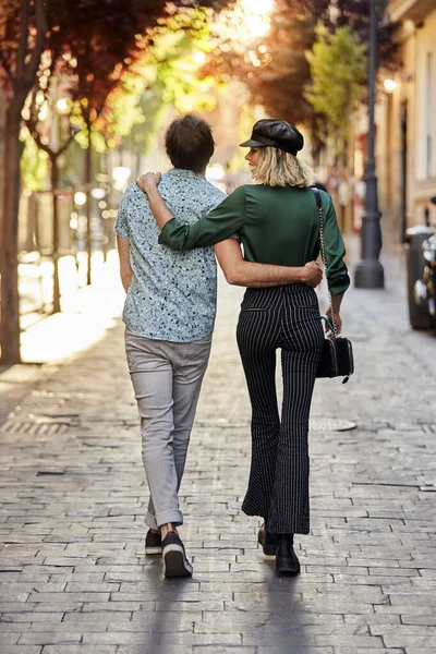 Couple walking on street away from camera. — Stock Photo, Image