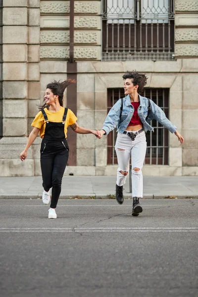 Two teenager girls running down street. — Fotografia de Stock