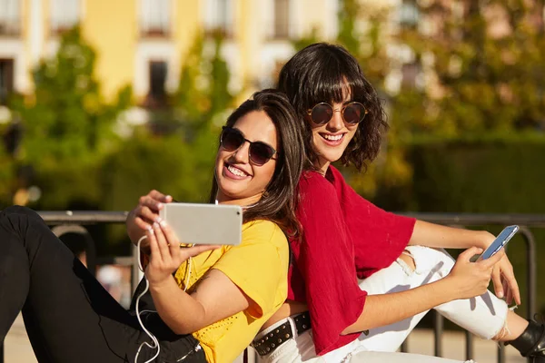 Dos chicas adolescentes sentadas y tomando una selfie. — Foto de Stock