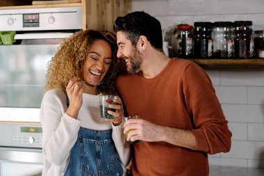 Çift gülüyor ve mutfakta duruyor..