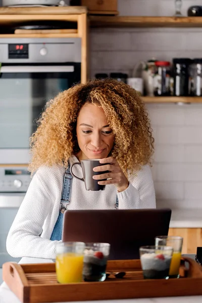 Wanita yang menggunakan laptop di dapur. — Stok Foto
