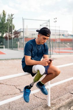 Telefonu kullanan engelli genç sporcu