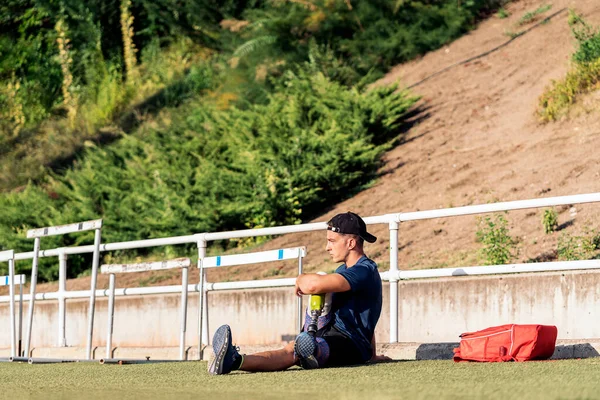 Atleta hombre discapacitado estiramiento con prótesis de pierna . — Foto de Stock