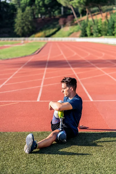 Atleta hombre discapacitado estiramiento con prótesis de pierna . — Foto de Stock