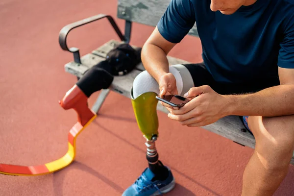 นักกีฬาหนุ่มพิการใช้โทรศัพท์ — ภาพถ่ายสต็อก