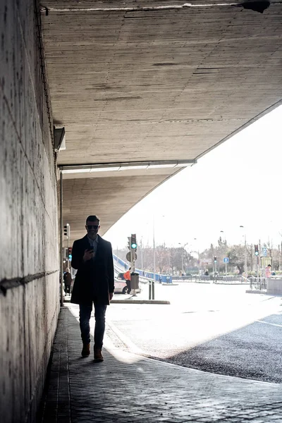 İş adamı sokakta akıllı telefonunu kullanıyor..