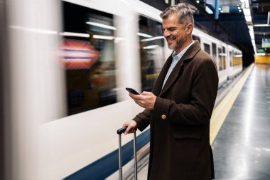 Yeraltında akıllı telefon kullanan bir iş adamı..