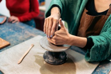 Sanat çömlek atölyesinde balçığı şekillendiren tanınmamış kişinin resmi..
