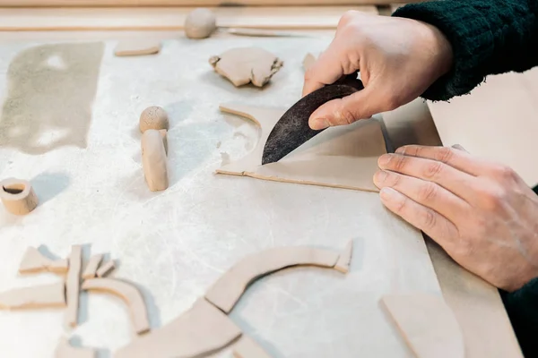 Stock photo of unrecognized person shaping clay in pottery class.
