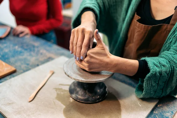 Stock photo of unrecognized person shaping clay in art pottery workshop.