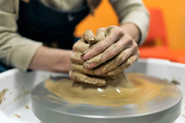 Stock photo of unrecognized person using potter\'s wheel during pottery class.