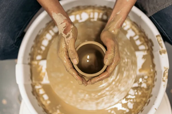 Stock photo of unrecognized person using potter\'s wheel during pottery class.