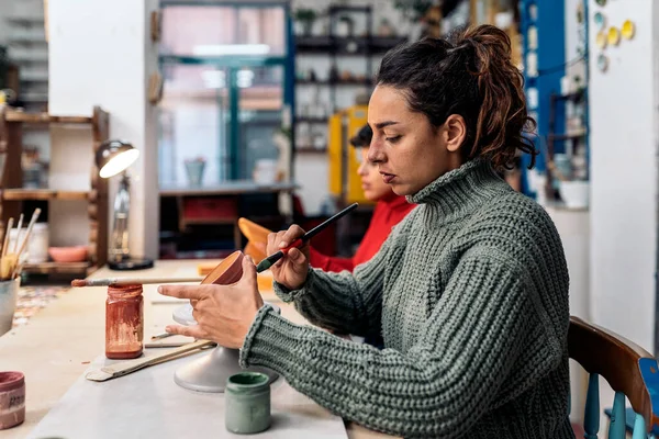 陶芸教室で筆を使っている女性の写真 — ストック写真