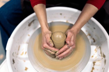 Çömlekçilik dersinde tanımadığın birinin çömlekçi çarkı kullandığının resmi..
