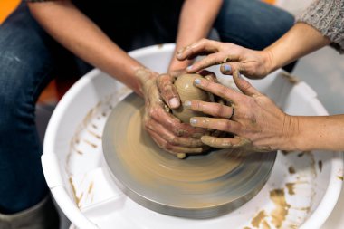 Çömlekçilik dersinde tanımadığın birinin çömlekçi çarkı kullandığının resmi..