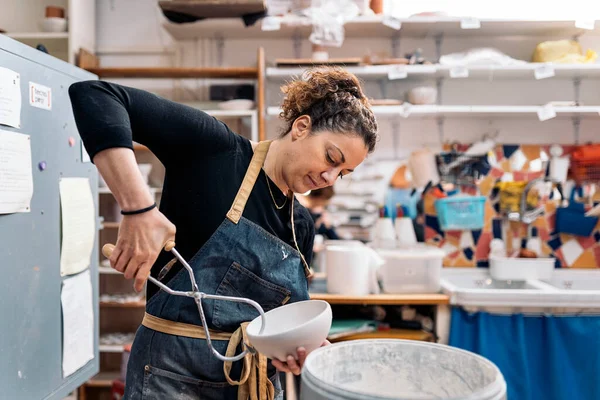 陶芸アトリエで働くエプロンの濃縮女性のストックフォト — ストック写真