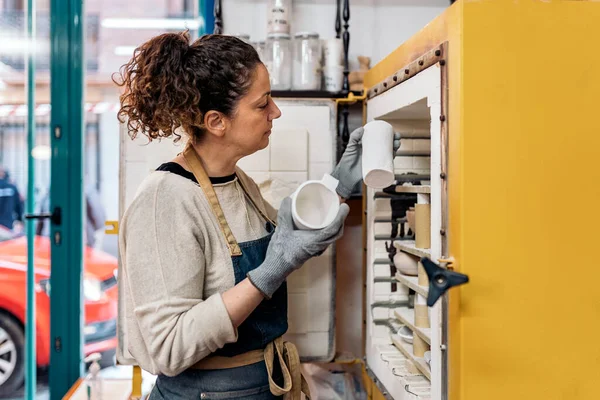 Foto Mujer Concentrada Delantal Trabajando Taller Cerámica — Foto de Stock