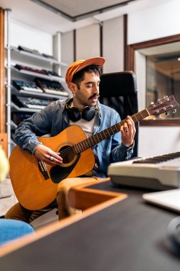 Müzik stüdyosunda gitar çalan konsantre sanatçının stok fotoğrafı..