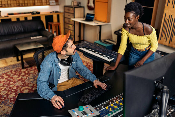 Stock photo of cool artists working in professional music studio.