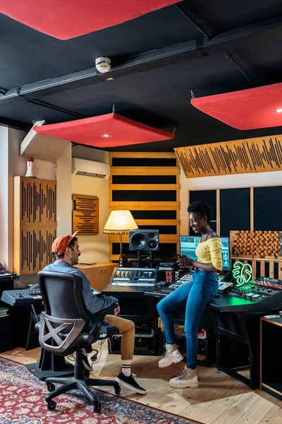 Stock photo of music producer and black singer talking in the music studio.
