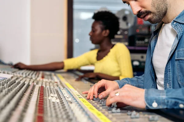 Stock photo of unrecognized person using panel control in professional music studio.