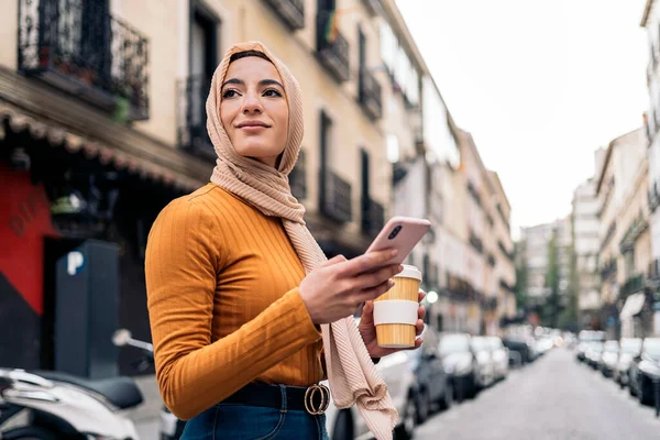 Όμορφη Νεαρή Μουσουλμάνα Γυναίκα Φλιτζάνι Καφέ Χρησιμοποιώντας Κινητό Της Τηλέφωνο — Φωτογραφία Αρχείου
