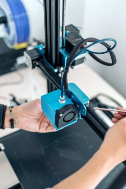 Modern 3D yazıcıyı tamir eden tanınmamış teknisyenin stok fotoğrafı.
