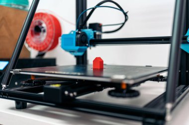 Stock photo of modern 3d printer printing cool red design.