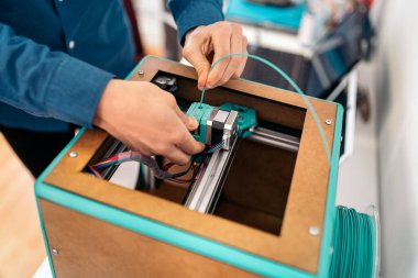 Modern 3D yazıcıyı tamir eden tanınmamış teknisyenin stok fotoğrafı.