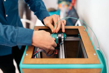 Modern 3D yazıcıyı tamir eden tanınmamış teknisyenin stok fotoğrafı.