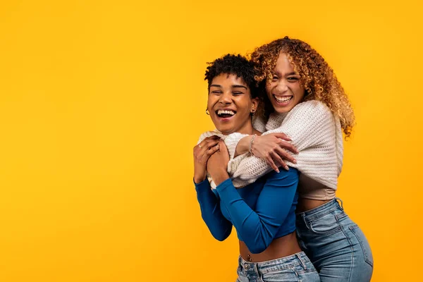 Stock Photo Cheerful Afro Women Hugging Each Other Studio Shot — Foto Stock