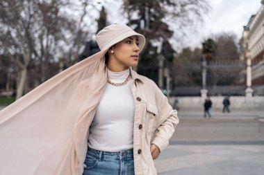 Beautiful muslim woman wearing head scarf posing and looking to the side in the street.
