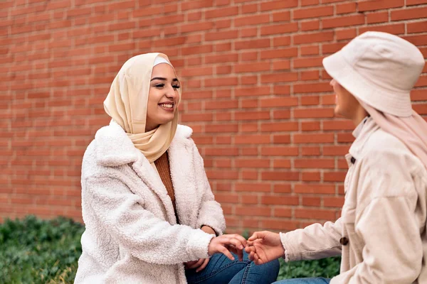 Cheerful Young Women Wearing Hijab Talking Sitting Bench — Fotografia de Stock