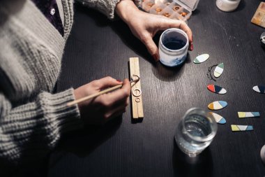 Tanımlanamayan bir kadının mücevher atölyesinde boya kullanırken çekilmiş resmi..