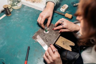 Takı atölyesinde aletlerle çalışan tanınmamış sanatkar kadınlar.