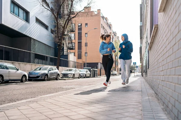 Χαρούμενη Μουσουλμάνα Που Φοράει Χιτζάμπ Τρέχει Στο Δρόμο Φίλη Της — Φωτογραφία Αρχείου