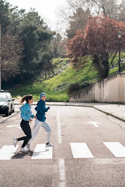 Cheerful Active Girls Wearing Sports Clothes Running Crossing Street — Fotografia de Stock