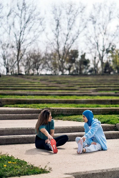 Multicultural Female Friends Sitting Park Stretching Legs Work Out Wearing — ストック写真