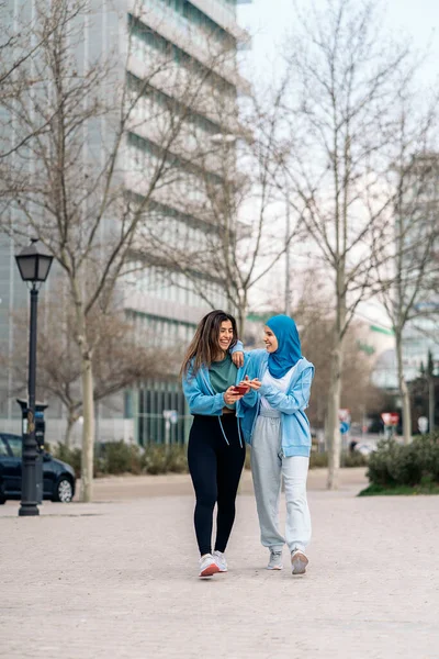 Active Muslim Girl Her Friend Walking Street Using Mobile Phone — ストック写真