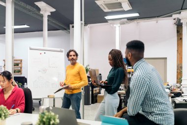 Boomer business man writing in a whiteboard during a meeting in the office.