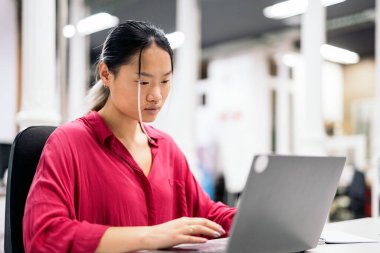 Young asian office worker using laptop and working in the office. Co-working concept.