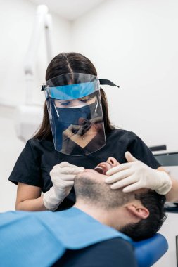 Unrecognized man lying down in dentist chair during checkup revision.