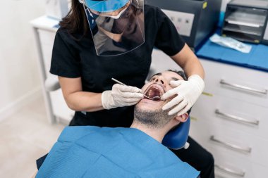 Unrecognized man lying down in dentist chair during checkup revision.