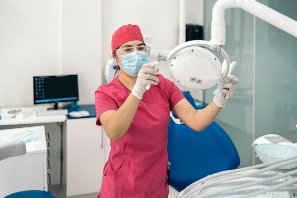 Female Dentist Working Modern Dental Clinic Wearing Face Mask She — стоковое фото