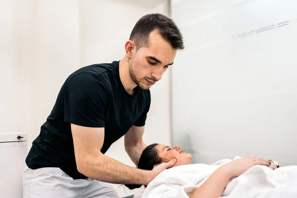 Male Physiotherapist Giving Neck Massage Relaxed Woman Lying Stretcher — Stok fotoğraf