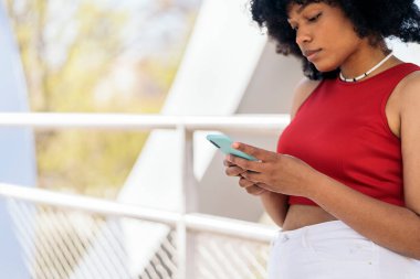 Sokakta cep telefonu kullanan afro saçlı güzel siyahi bir kadın..